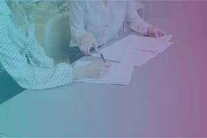 two women at a conference table comparing notes