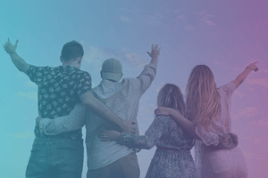 four people with their backs turned and arms around each other